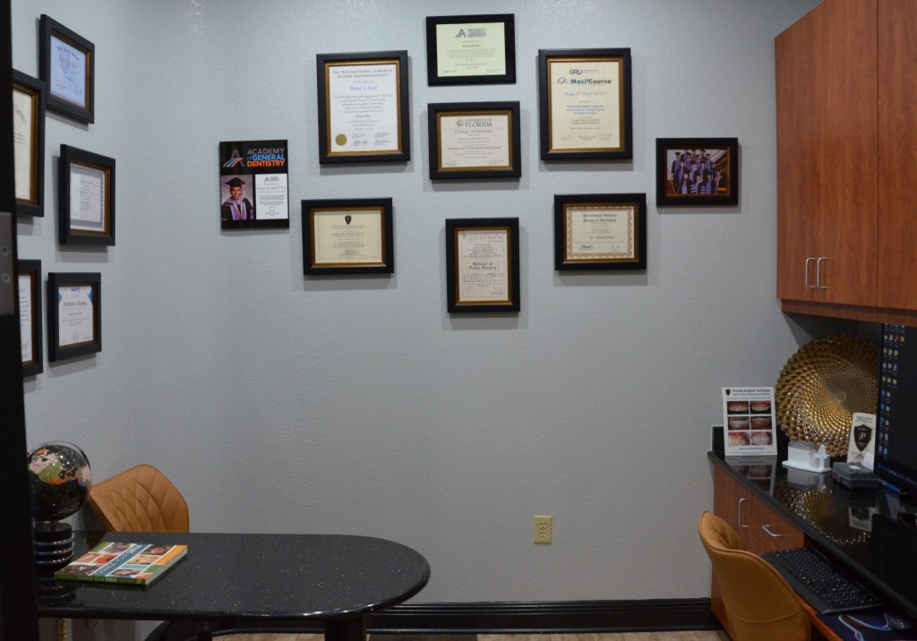 Wall display of framed professional certificates, diplomas, and credentials