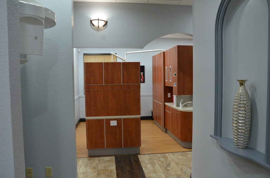 Interior hallway view showing wooden cabinetry and warm lighting in dental office corridor