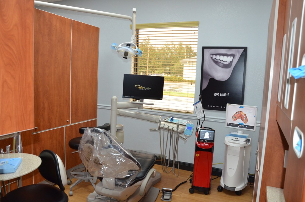 Dental treatment operatory with patient chair, computer monitor, equipment, and wooden privacy panels