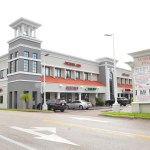 Modern multi-story medical/dental office building with white and gray architecture, tower features, and parking area