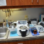 Dental lab workstation with sink, instruments, mixing equipment, and various laboratory supplies