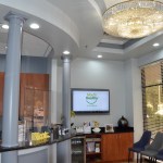 Elegant dental office reception with crystal chandelier, modern decor, and seating area